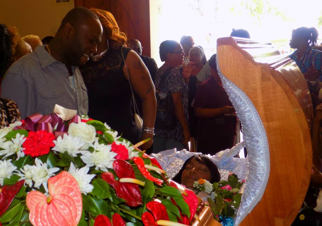Relatives of Melissa Tricia Emmanuel cry near her open casket during her funeral service at the Santa Rosa RC Church in Arima yesterday.