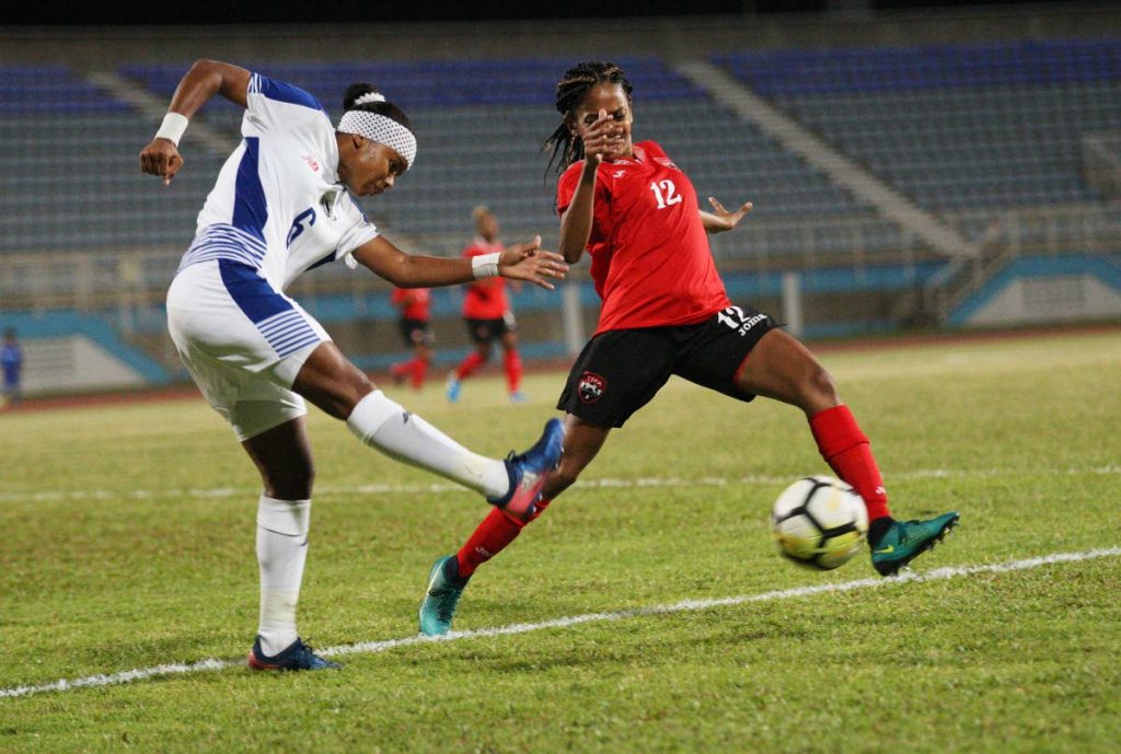 TT’s Shanelle Arjoon,right, defends a shot from Kenia Rangel, of Panama, on Thursday during a international friendly held at the Ato Boldon Stadium, Couva.