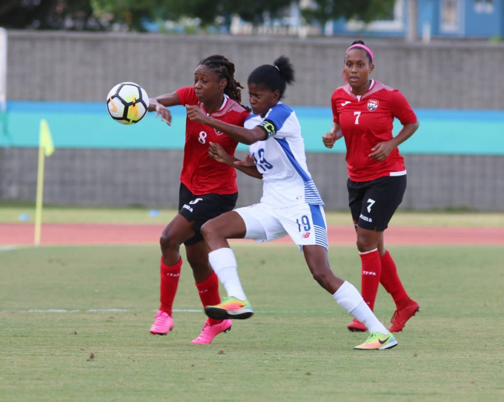 Trinidad and Tobago’s Patrice Superville (left) battles for the ball with Panama’s Natalia Urranaga while fellow TT player Jonelle Cato (right) looks on, during the first half of Saturday’s match.