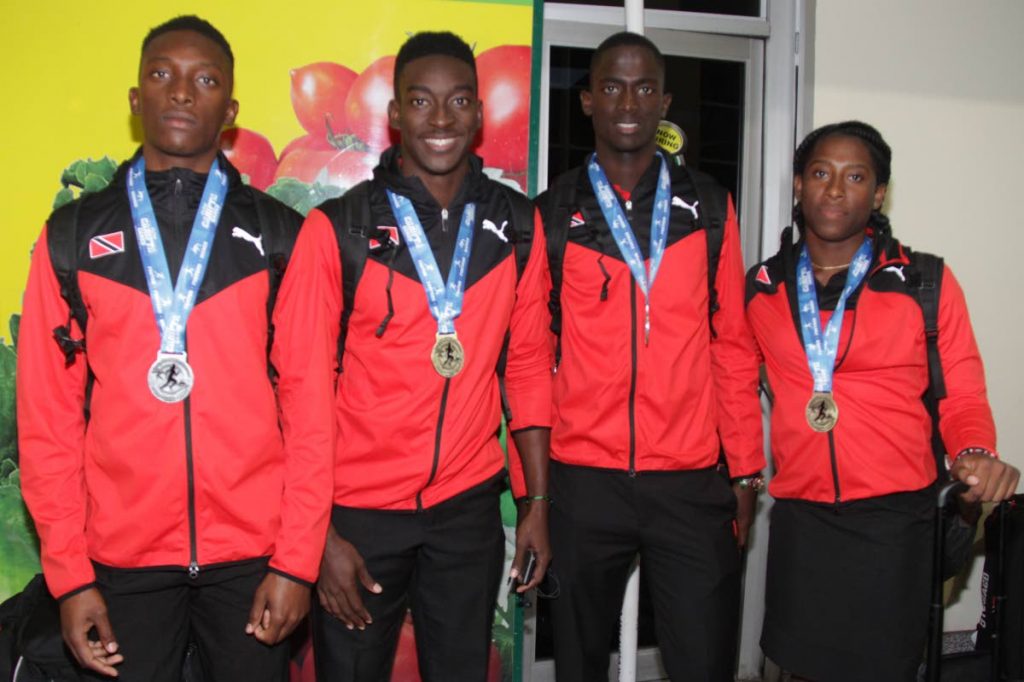 Trinidad and Tobago’s Carifta athletes pose with their medals on their return home on Tuesday night 
at the Piarco International Airport.