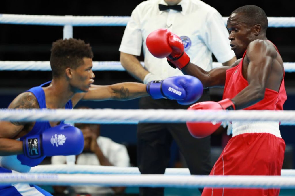 Trinidad and Tobago’s Michael Alexander, left, fires a left hook at Kenya’s Nicholas Okoth during their men’s 60kg lightweight bout yesterday at the Commonwealth Games in Gold Coast, Australia.