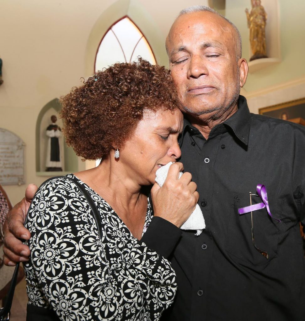 OUR GIRL IS GONE: Raphael Chuniesingh consoles his wife Fabiana yesterday at the funeral for their murdered daughter Christine at the Santa Rosa RC Church in Arima. PHOTO BY AZLAN MOHAMMED