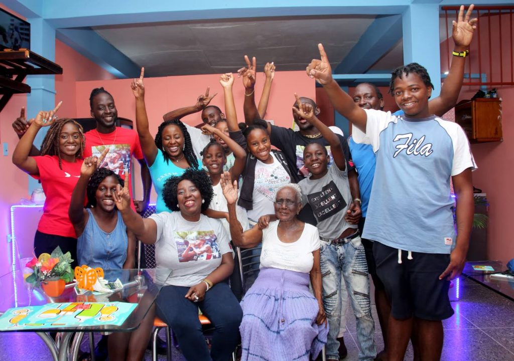 Relatives and friends of Jereem Richards, including his mother Yvette Wilson (seated center) and grandmother Deaprice Wilson (seated right) celebrate his victory at the family’s home in Point Fortin yesterday.