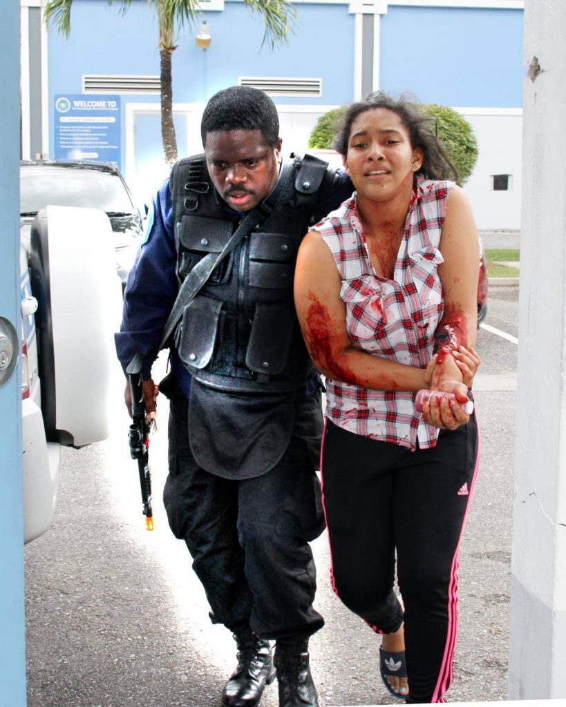 An 'injured student ' is rescued by a police officer at the International School of Port of Spain in Westmooring  during an active shooter re-actment drill .14-04-18 PHOTO SUREASH CHOLAI