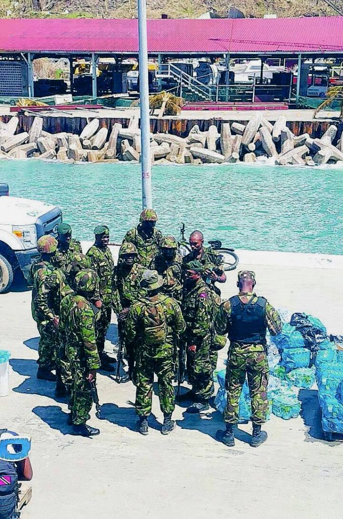 Trinidad and Tobago Defence Force officers stand next to food items taken to Dominica by TT Coast Guard vessel, TTS Moruga (CG 27), after Hurricane Maria.