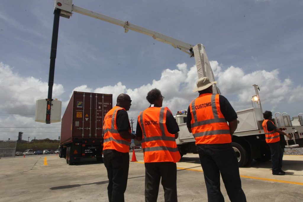 Security scanner: Customs officers look on as mobile vehicle and cargo scanner is installed at the Port of Point Lisas on April 18 as part of security initiative between the US and TT. PHOTO BY LINCOLN HOLDER