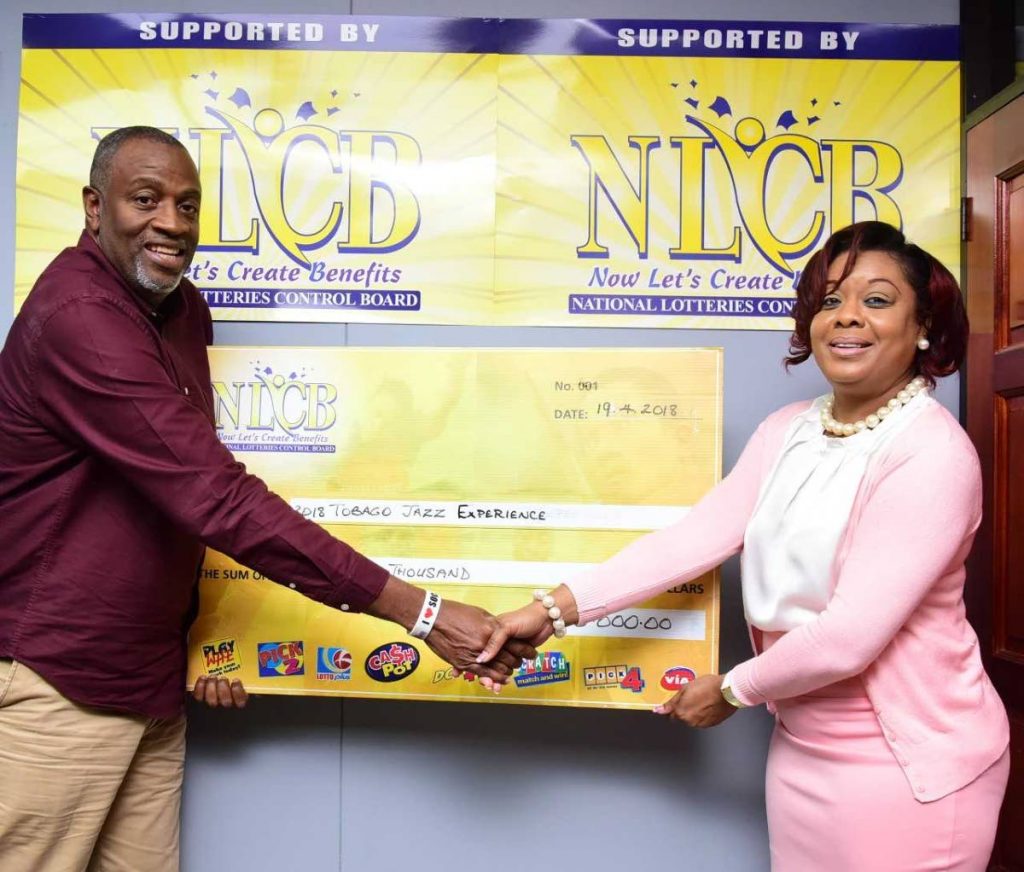 Susan Worrell of NLCB marketing and public relations presents a cheque for  $100,000 to George Leacock, chairman of the Tobago Festivals Commission.