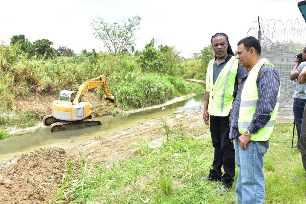 Minister of Works and Transport Rohan Sinanan and PURE director Hayden Phillip look at work at the Cipero river, San Fernando, yesterday. PHOTO COURTESY MINISTRY OF WORKS