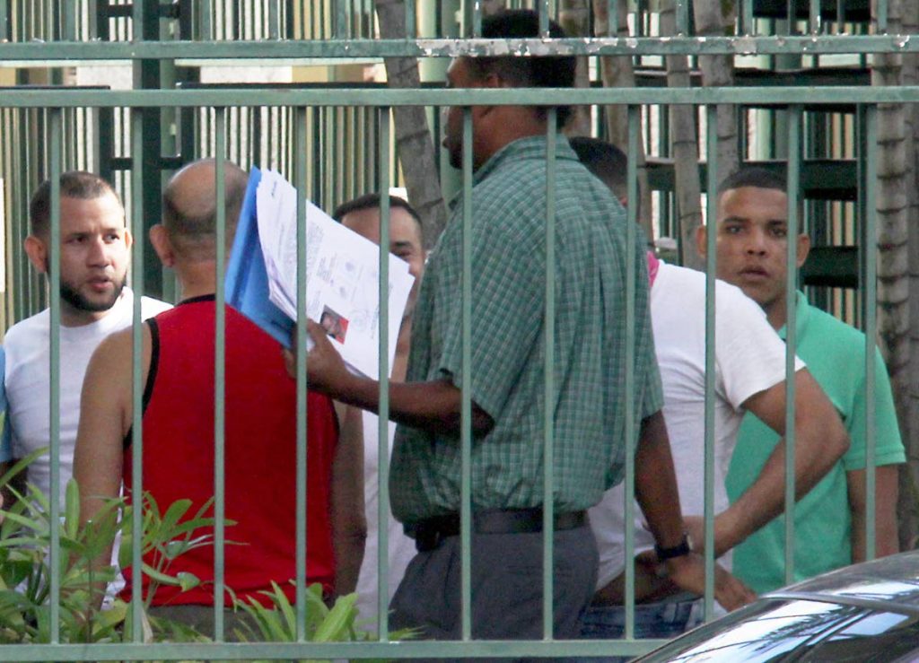 FLASHBACK: A National Security Ministry official (centre) processes Venezuelan nationals at the Venezuelan Embassy last Friday. On Sunday, 82 detainees were repatriated to Venezuela.