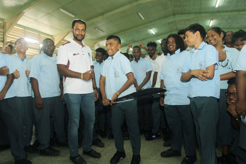 West Indies cricketer Denesh Ramdin poses with students of the Changuanas North Secondary School at the school yesterday after the launch of the 2018 Youth Cricket Series.