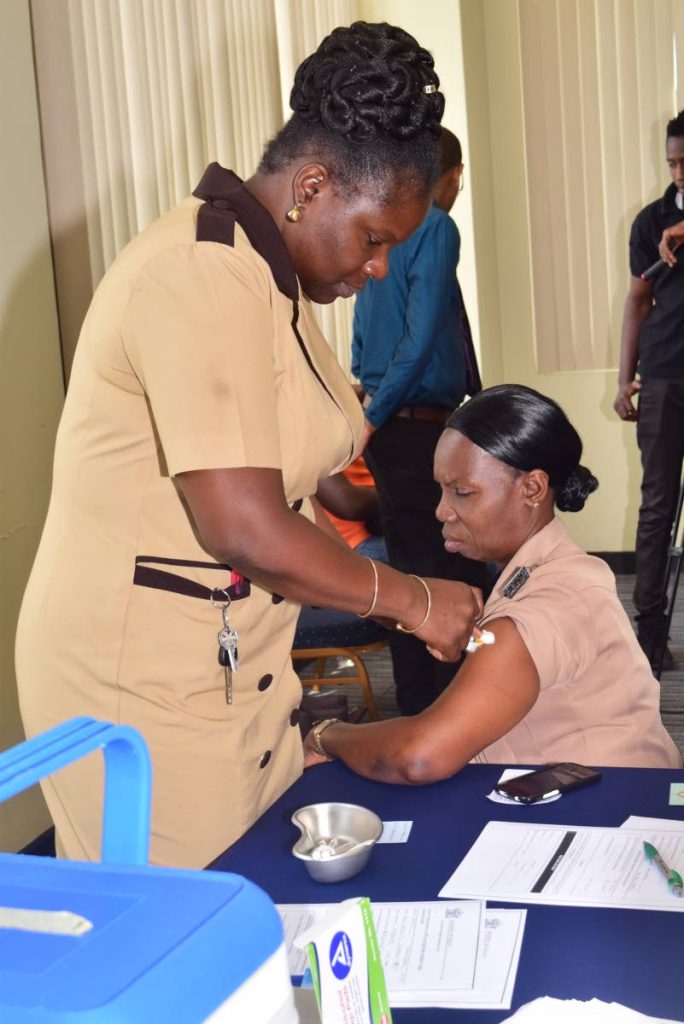 Division of Finance employee Susan John receives a flu vaccine shot from District Health Visitor (TRHA) Latoya McKenzie on at the Division’ Occupational Safety and Health Committee’s Health Fair held at the Victor E Bruce Financial Complex in Scarborough. April 2