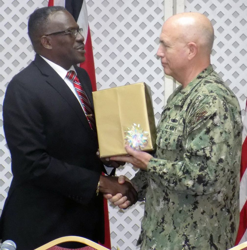 FOR YOU: National Security Minister Edmund Dillon presents a token to US Navy Southern Command leader Admiral Kurt Tidd during a press conference yesterday at the ministry in Port of Spain.
