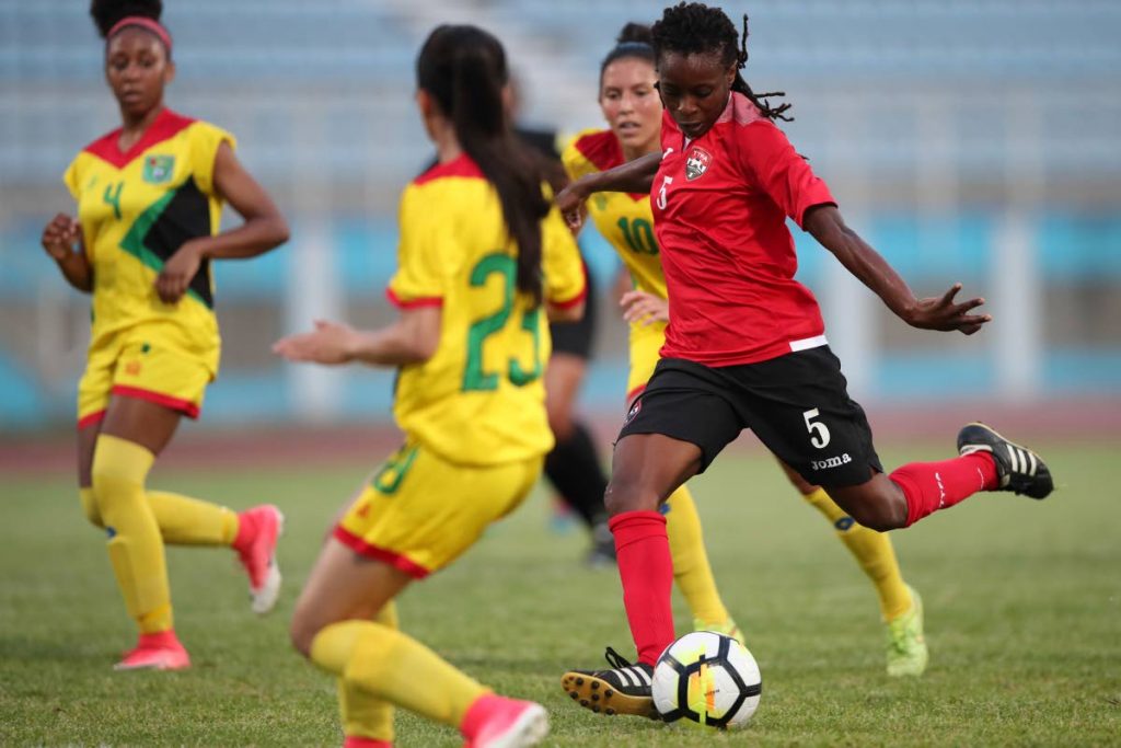 TT’s Jenelle Cunningham (#5) has a shot on goal between Guyana defenders Nailah Rowe (#4) Rylee Traicoff (#23) and Mariam El-Masri (#10), during the CFU Women’s Challenger Series 2018 between TT (red) and Guyana (yellow) at the Ato Boldon Stadium, Couva, yesterday.