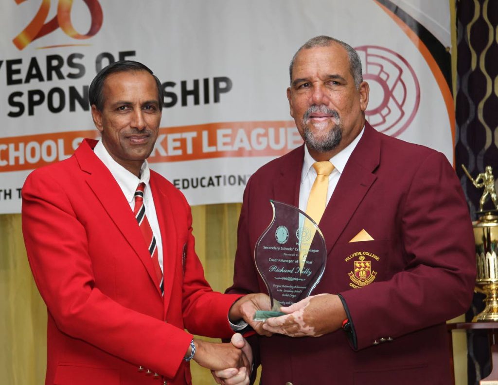 Surujdath Mahabir, left, president of the Secondary Schools Cricket League, presents an award to Hillview College coach Richard Kelly at the SSCL Awards last year.