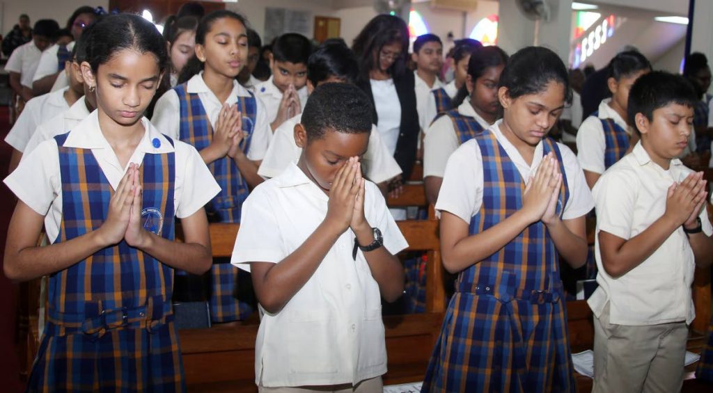 GUIDE US LORD: Students of Grant Memorial Presbyterian primary school pray yesterday at the Susamachar Presbyterian Church in San Fernando. They are among 19,000 students across the nation who will sit the SEA exam today. PHOTO BY VASHTI SINGH