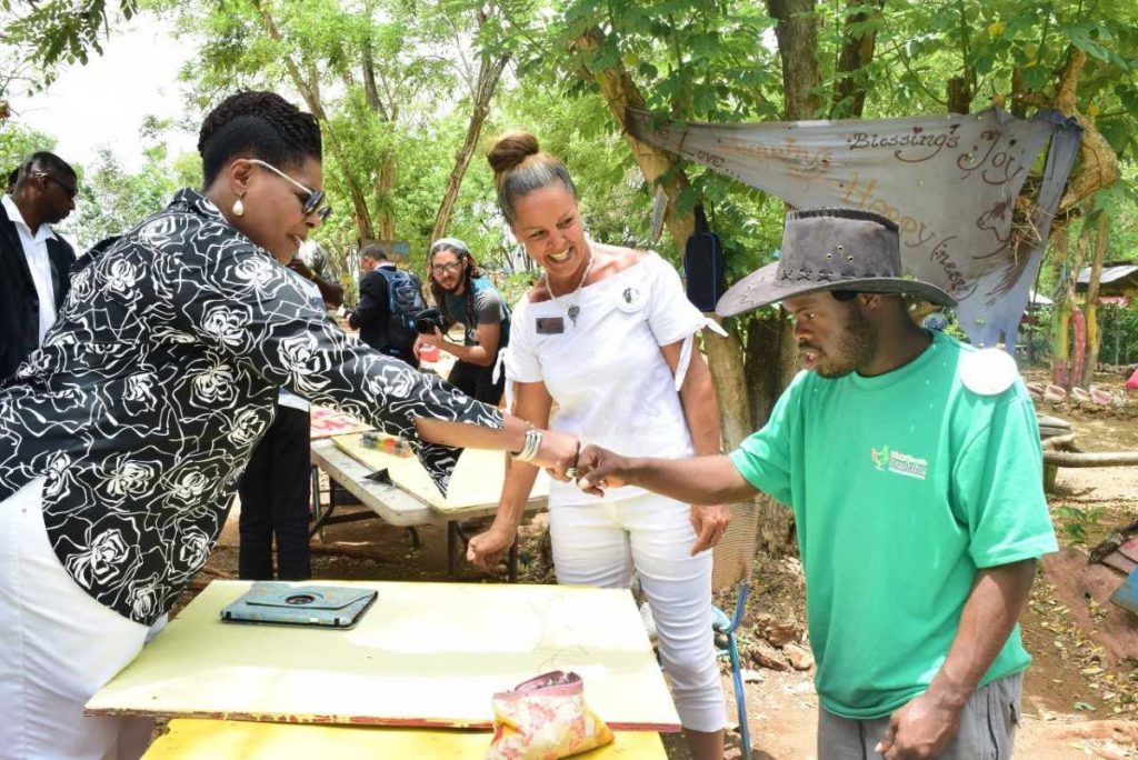 PRESIDENTIAL BOUNCE:  President Paula-Mae Weekes ‘bounces’ longstanding member of Healing with Horses, Keron McLetchie, as president of the foundation, Veronika La Fortune smiles.  Weekes toured the foundation’s facilities at Buccoo, Tobago yesterday.   PHOTO BY VIDYA THURAB