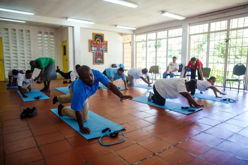 SoFit health and wellness programme coordinator Innocents Hamilton and Digicel Foundation project coordinator, Diana Mathura-Hobson assist the students during the floor exercise at one of their SoFit session.  