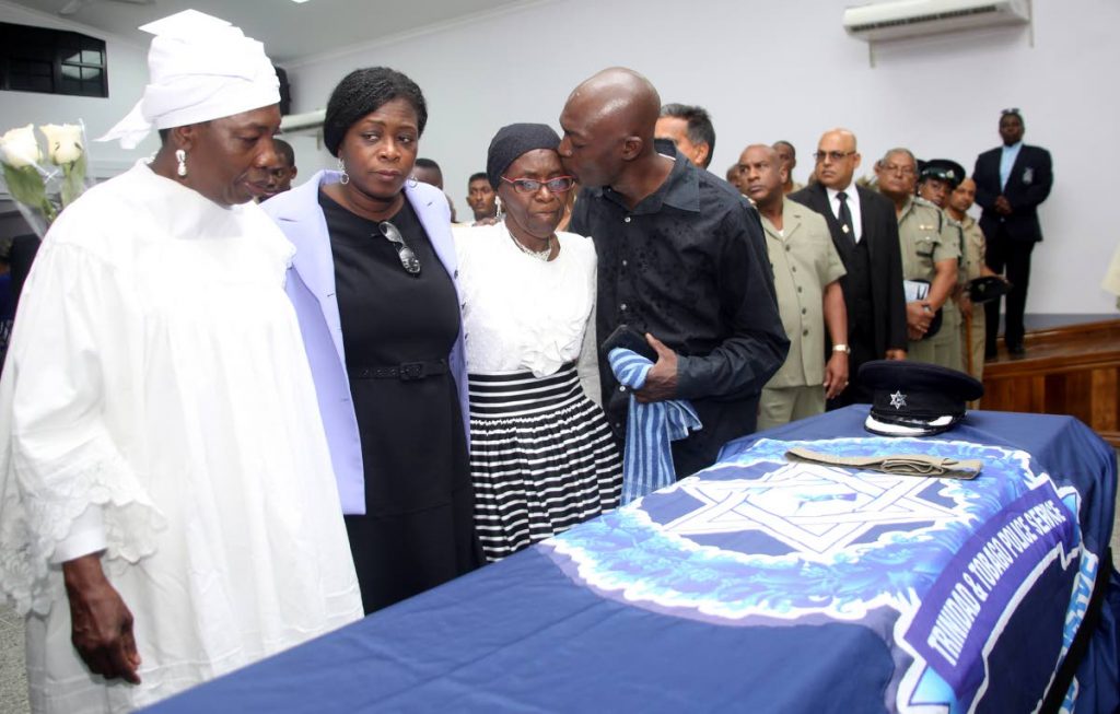 A relative consoles Lucille Marrain, widow of Archbishop Amilius Marrain, 
alongside family members during his funeral at Pleasantville Community Centre, 
Pleasantville on May 8. Marrain was the leader of the Triune Shouters Baptist 
Incorporated and a retired policeman. PHOTOS BY VASHTI SINGH