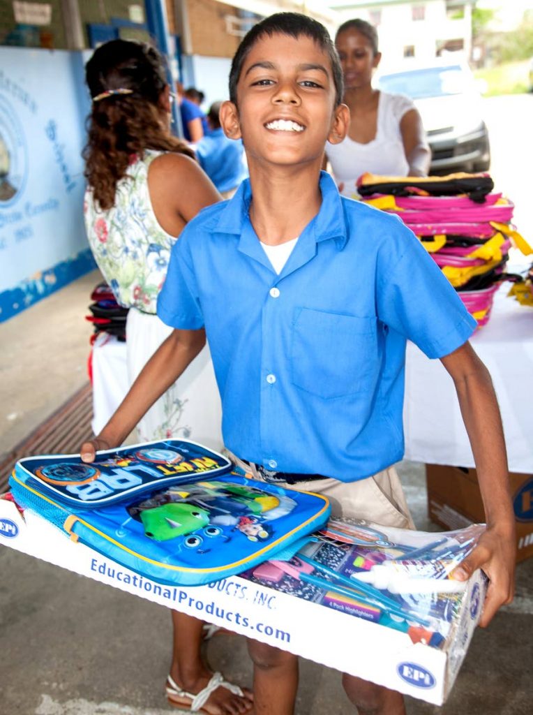 A pupil of St Julien Presbyterian School shows off his package from the Kowlessar family.