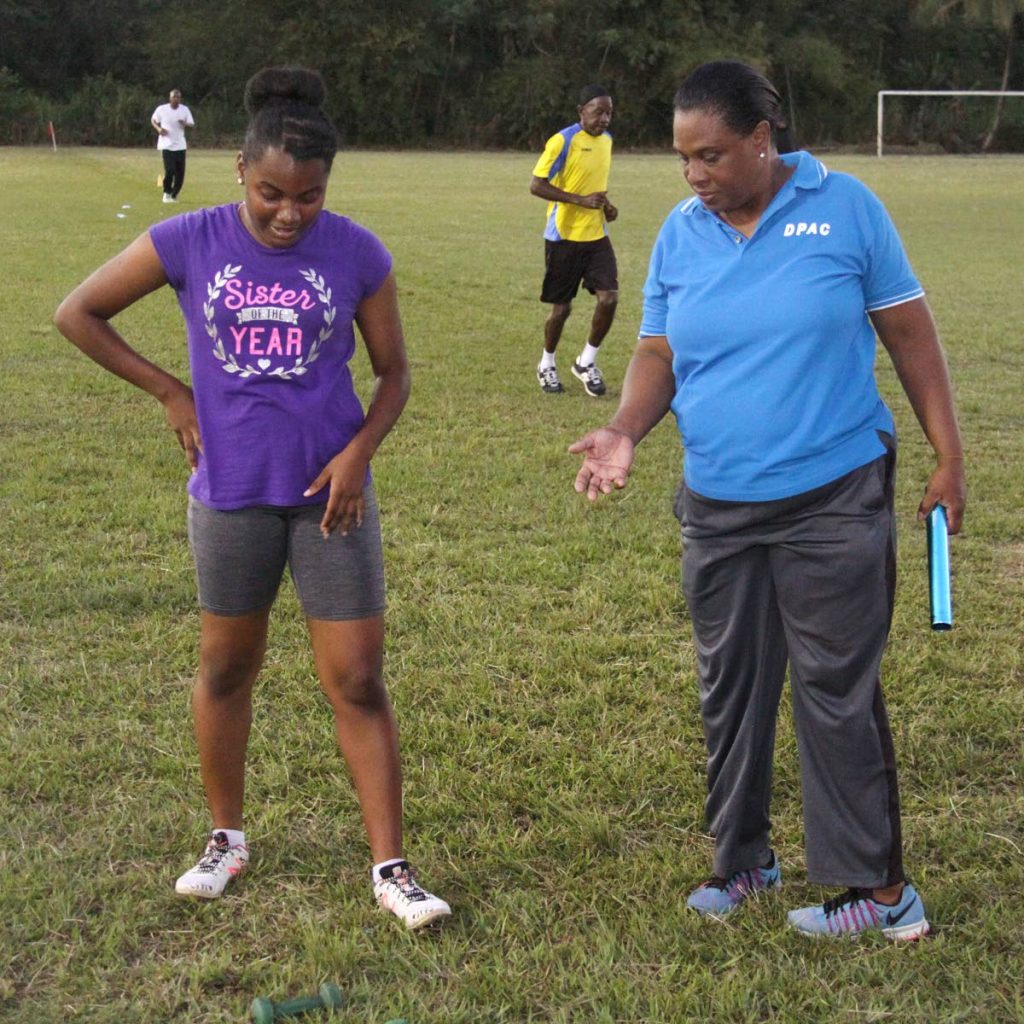 Coach Portia St Louis, gives advice to one of her athletes at the D’Abadie Recreation Ground.