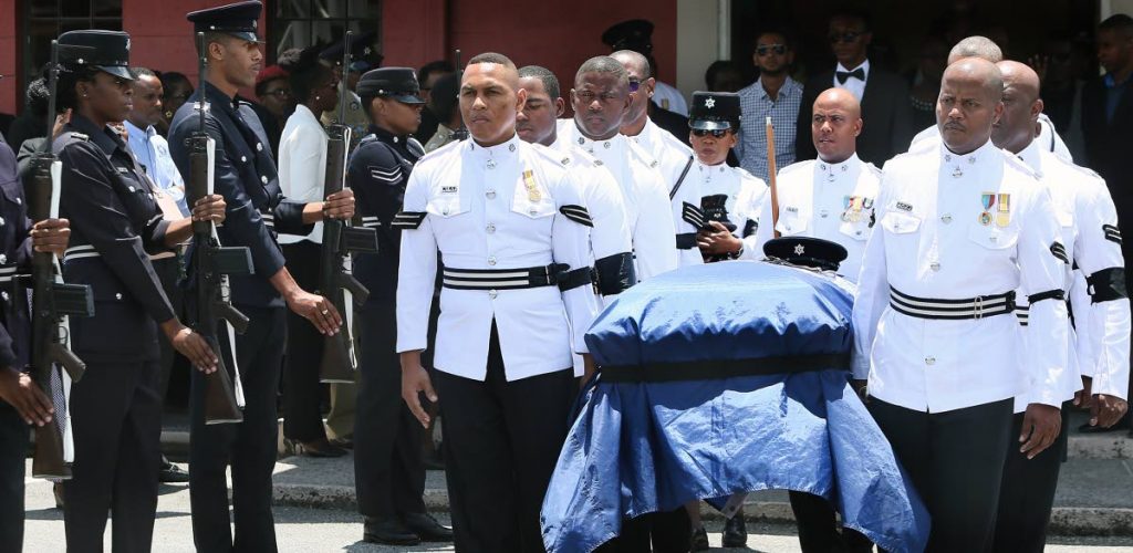 FINAL JOURNEY: Policemen carry the casket of Sgt Darryl Honore at the end of his funeral yesterday in Chaguanas. PHOTO BY AZLAN MOHAMMED