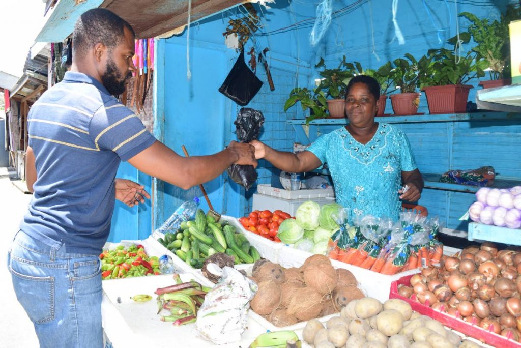 Produce vendor Jennifer Noel sells to a customer from her Scarborough market stall on Monday.