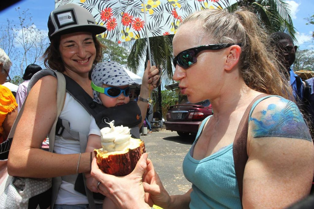 COCOA IN THE SUN: English visitors Allie Adams, left, and Alison Frank with a cocoa during their visit to the Rancho Quemado Estates which held a cocoa fair on Thursday.