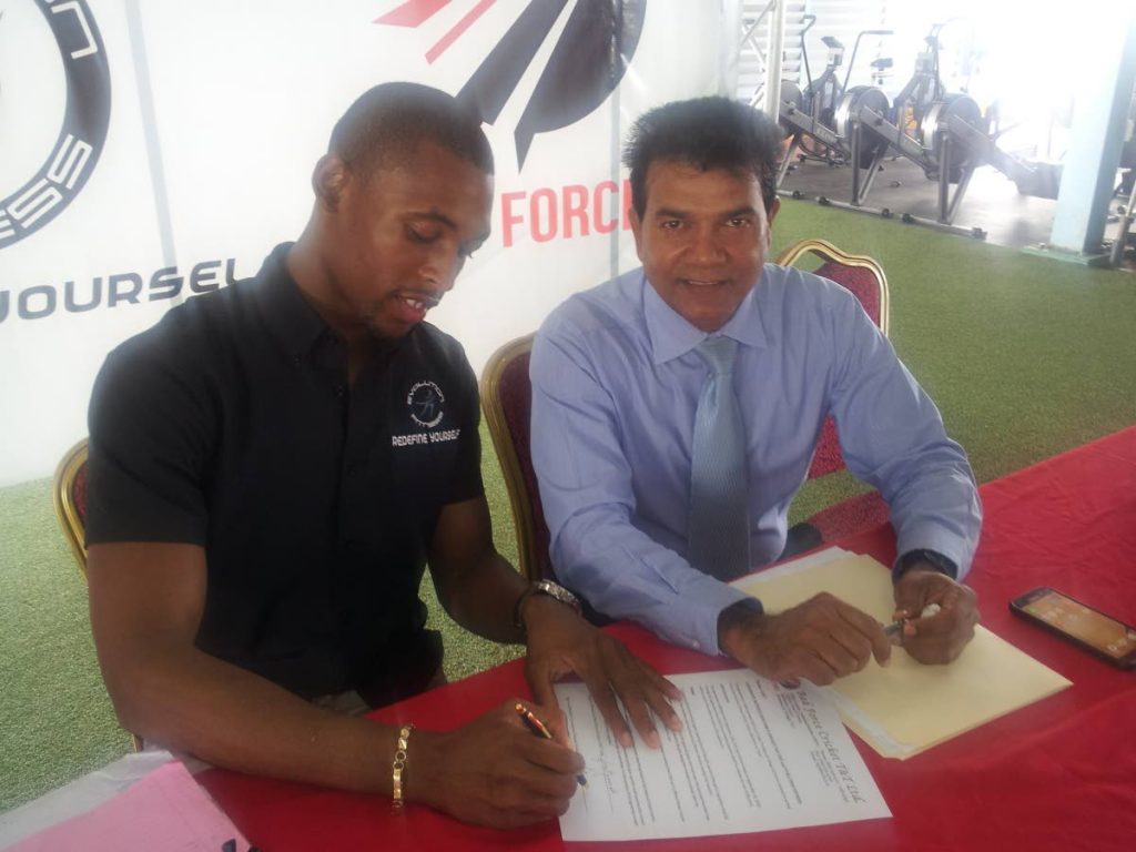 Former CEO of the TT Cricket Board Suruj Ragoonath, right, and general manager of the Evolution Fitness Gym Rhondell Brown sign an agreement last year at the Chaguanas gym.