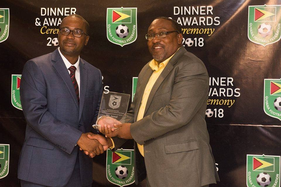 Jamaal Shabazz, right, collects the Presidential Award at the Guyana Football Federation awards ceremony.