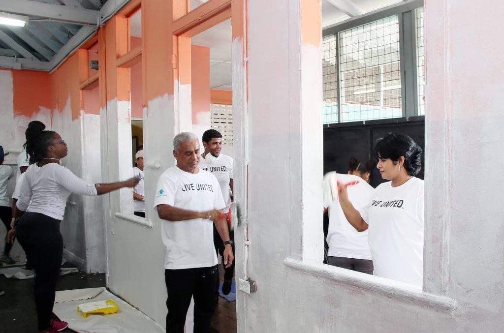 Republic Bank's Suresh Supersad, regional sales manager and retail banking head, and Geeta Harricharran, branch sales manager RBL's Park steet, at right, are joined by the bank's staffers to repaint the St Rose's RC Primary School in Port of Spain as part of their project for United Way's Day of Caring. 