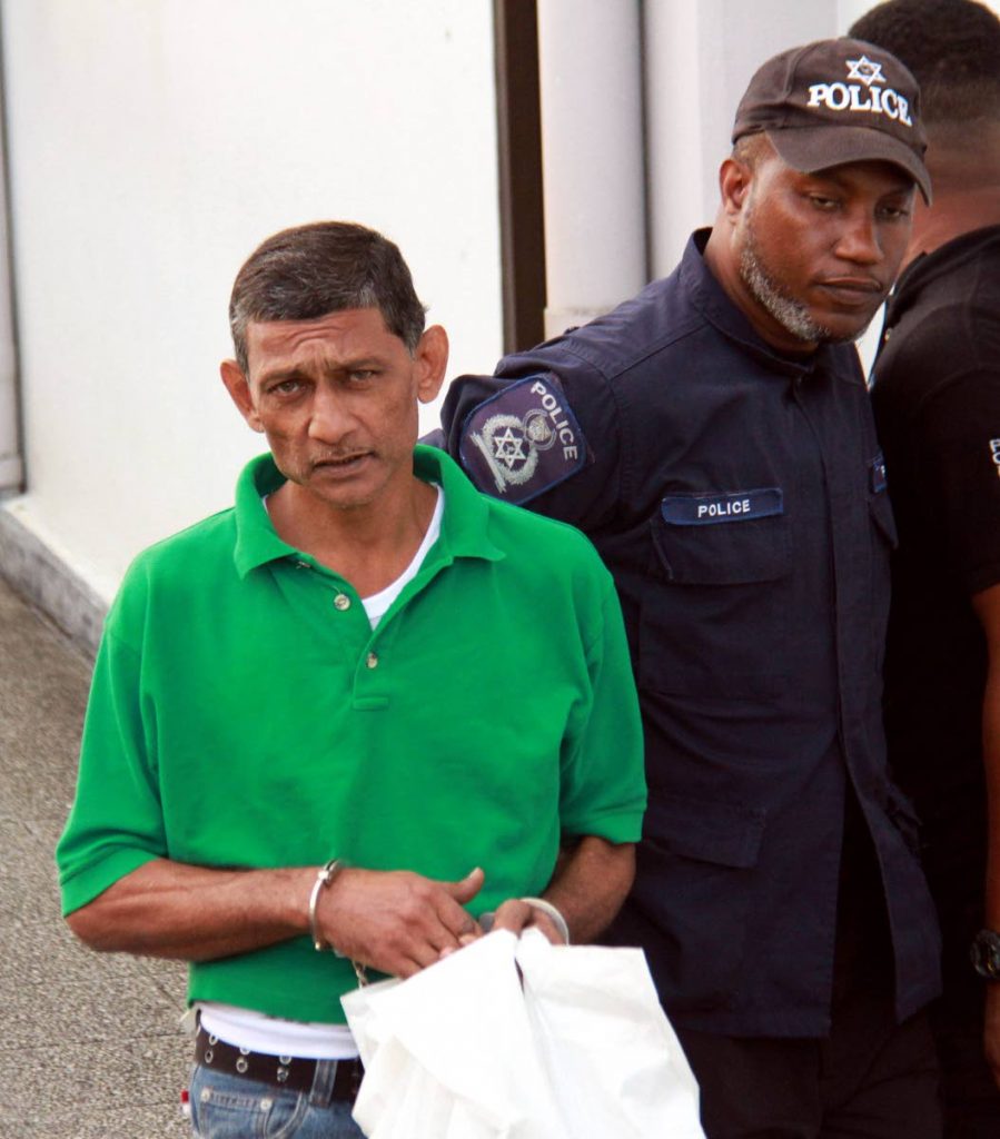 OFF TO JAIL: Doubles 
vendor Nizam Mohammed, 45, is led away to begin 
serving his sentence for throwing gasoline on a man and lighting him afire eight years ago.   PHOTO BY ANIL RAMPERSAD
