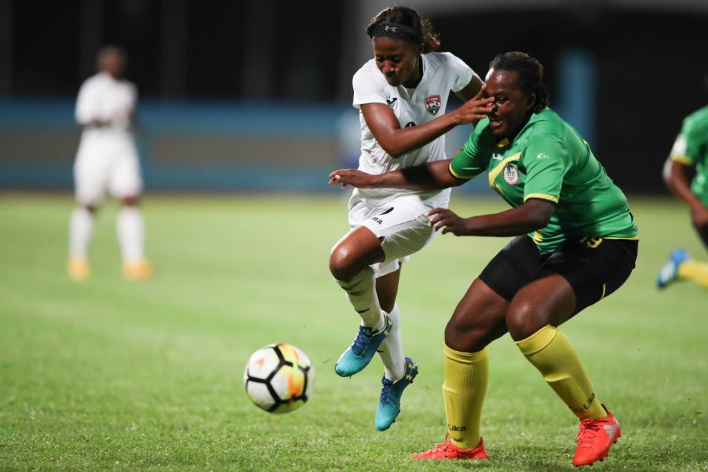TT’s Mariah Shade, left, skips past Dominica’s Kendra Francis during their CONCACAF Women’s World Cup Qualifier, Caribbean Round match at the Ato Boldon Stadium, Couva, yesterday.
