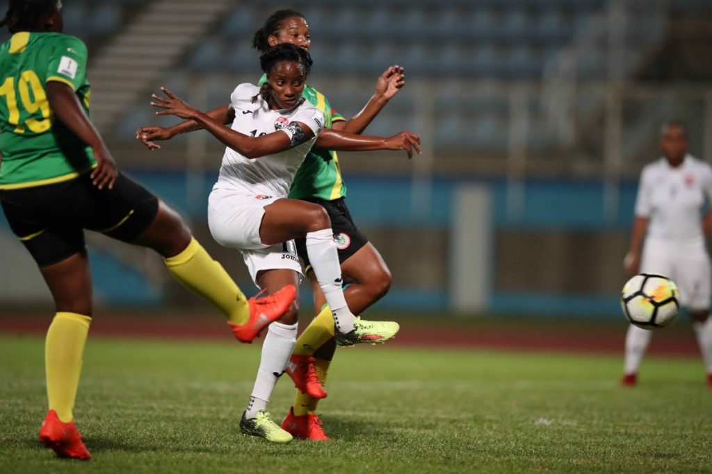 National forward Tasha St Louis, centre, shoots at goal against Dominica in a CONCACAF Women’s World Cup Qualifier, Caribbean Round match at the Ato Boldon Stadium, Couva, Monday.