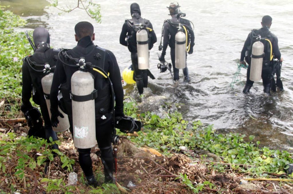 OFF TO SEARCH: Divers from the Coast Guard enter a pond in Ste Madeleine yesterday to search for a child. They left empty handed.