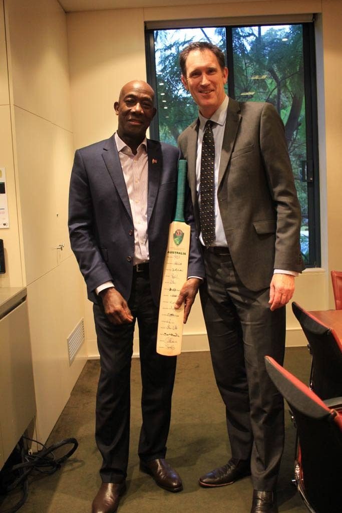 CEO of Cricket Australia, right, presents Prime Minister Dr Keith Rowley with a bat signed by the Australian cricket team. Rowley, who is currently in Australia, met with representatives of Cricket Australia, on Friday.