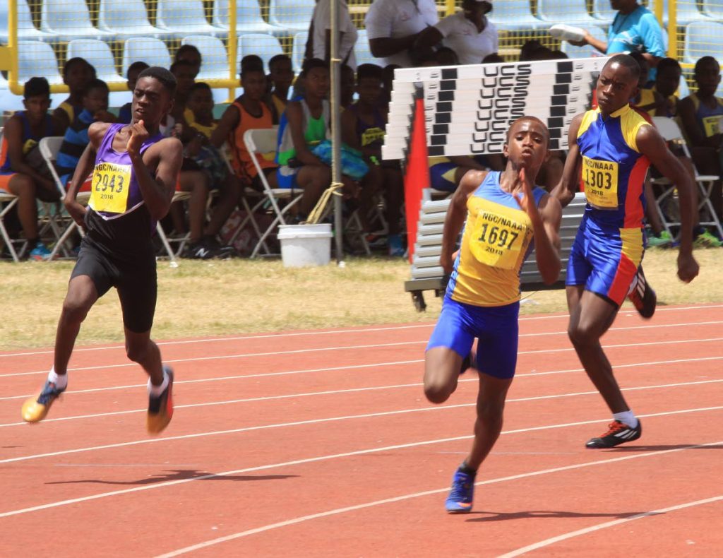 Joseph, centre, wins his heat yesterday, in the Boys U15 200m, with a time of 24.05 seconds, during action at the 30th annual Hampton Games, held at the Hasely Crawford Stadium, Port of Spain.
