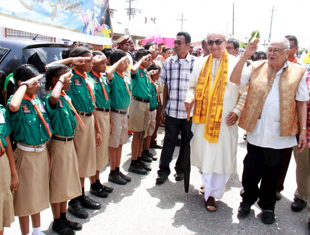 SALUTE: Secretary general of the Sanatan Dharma Maha Sabha Satnarayan Maharaj (right) 
and Dharmacharya Pundit Utam Maharaj (second from right) are saluted by scouts at Indian Arrival Day celebrations at the Parvati Girls’ Hindu College in Debe yesterday.