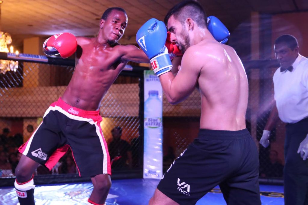 TT’s Kendell Phillip, left, unleashes a punch on Venezuela’s Emiliano Godoy in a kickboxing match 
at the RHAGE Mixed Martial Arts event at Cascadia Hotel, St Ann’s, recently.