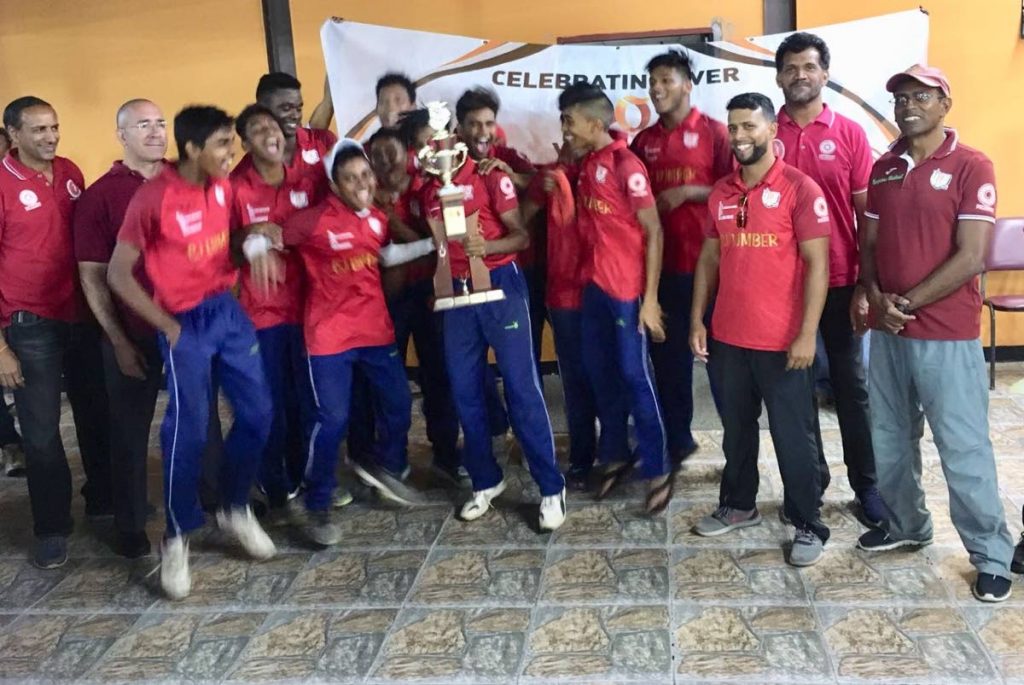 Presentation College players and management celebrate winning the Secondary Schools Cricket League (SSCL) Under-16 40-overs  title as SSCL president Surajdath Mahabir, left, looks on at the 
National Cricket Centre, Couva, on Tuesday.