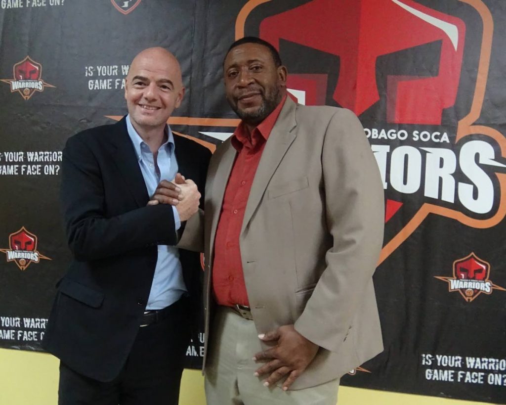 TTFA boss David John-Williams (right) shakes hands with current FIFA President Gianni Infantino at the TTFA office last year.