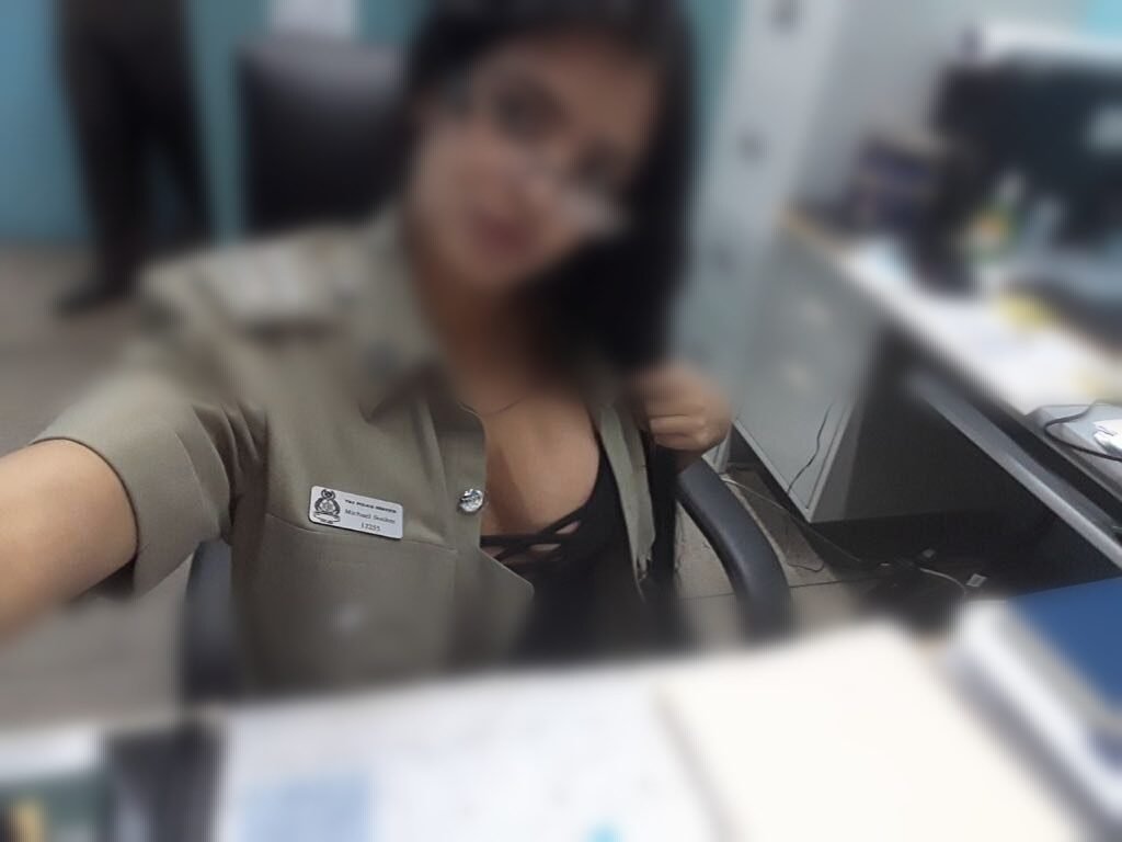 A young woman wearing the Ag Superintendent of Police is seen posing wearing lingerie in the charge room of a police station