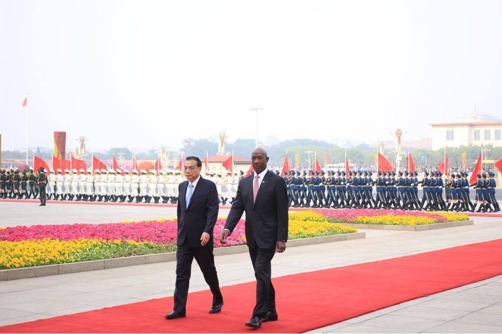 ON CHINESE SOIL: Prime Minister Dr Keith Rowley and Premier of the State Council of the People Republic of China leave after inspecting a guard of honour shortly after Rowley arrived in Beijing to kick off a state visit to that country. PHOTO COURTESY OFFICE OF THE PRIME MINISTER 