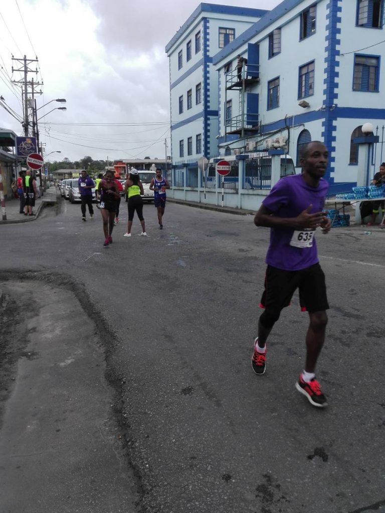 Bertie St Clair, right, enjoys a moderate pace as he competes in the Sweaters 5K on Thursday in Sangre Grande.