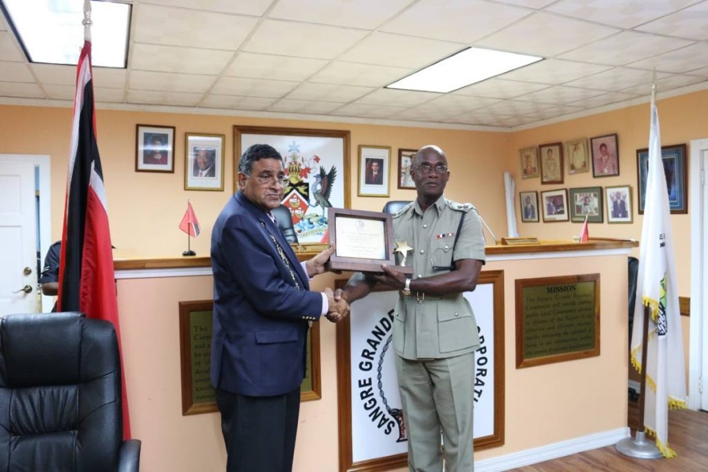 Chairman of the Sangre Grande Regional Corporation Terry Rondon, left, presents an award to Senior Superintendent of Eastern Division Garth Nelson during a ceremony honouring officers of the Eastern Division this morning. 