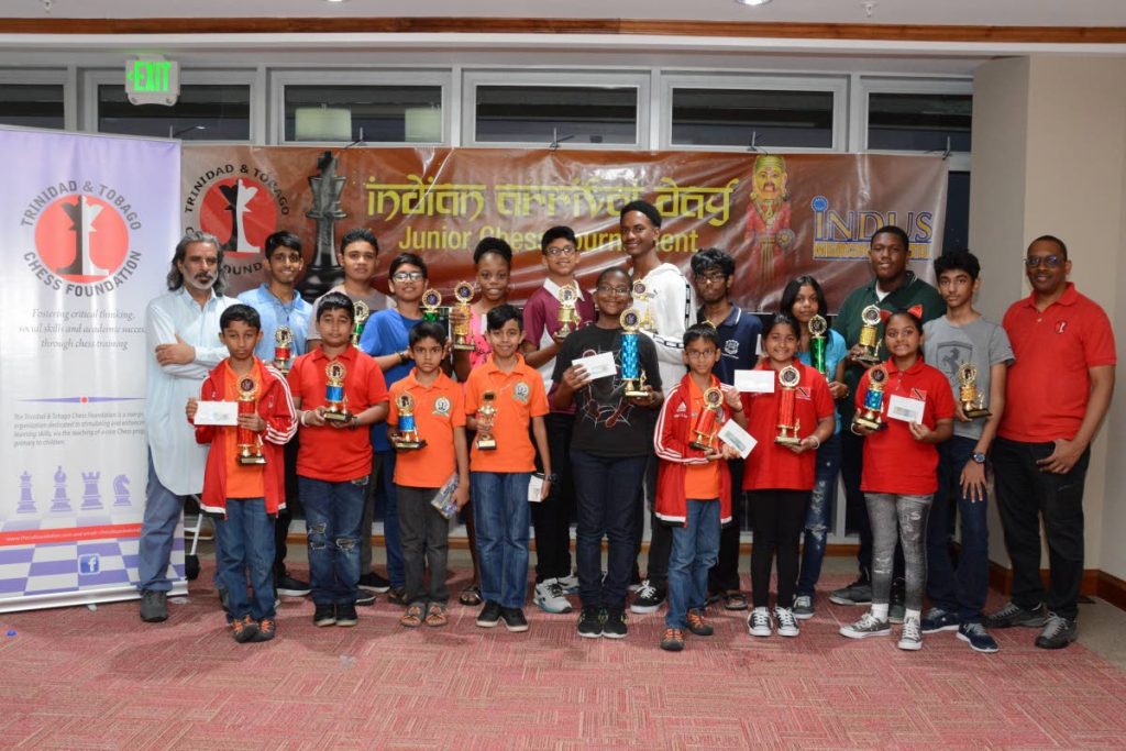 Winners of the Indian Arrival Day Chess competition pose with Ved Janwani, back left, Managing Director of Indus Merchant and Edison Raphael, right, President of the TT Chess Foundation.
