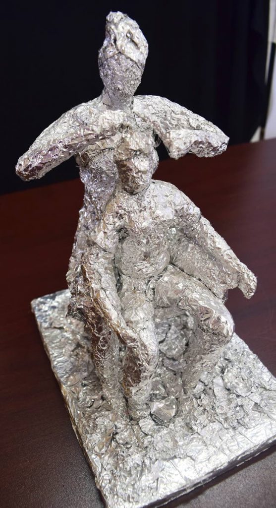 A foil sculpture of a woman combing a child’s hair by Wendel Moore.