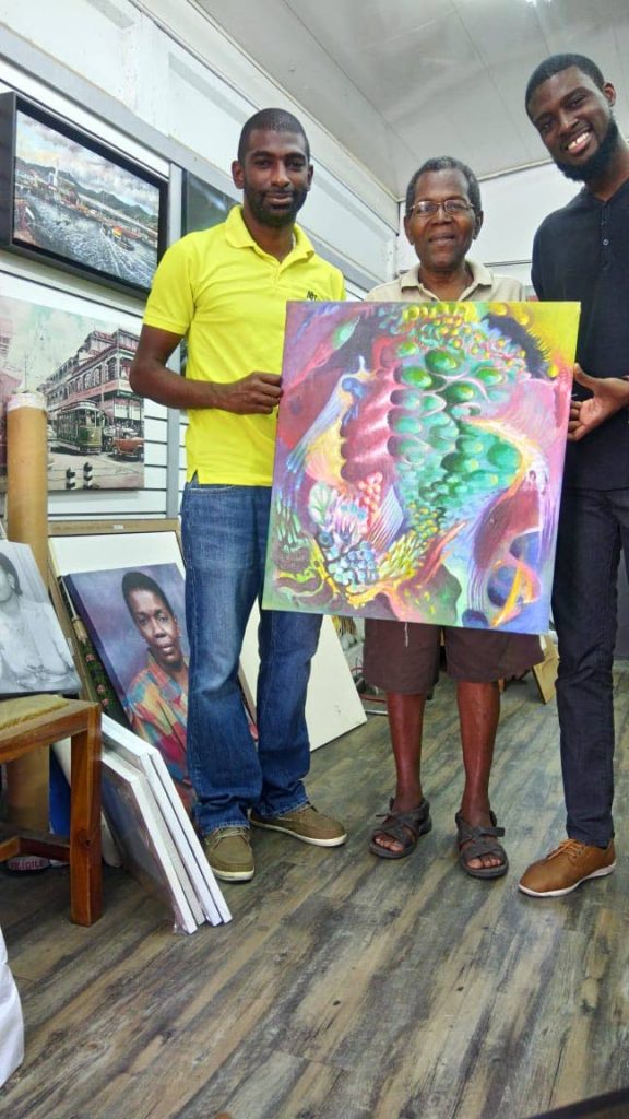 Artist Kevin Vincent, right, with iHUBtt owner Marlon Skerrette, left, and a representative of Cherish Frames. 