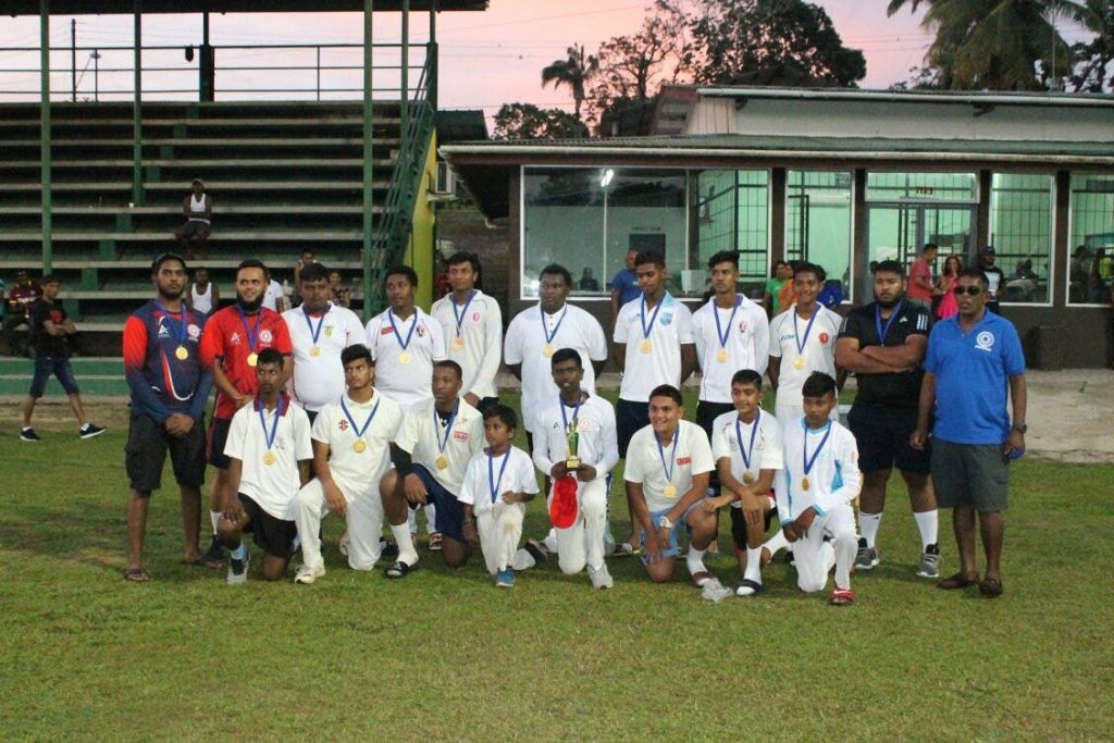 Powergen players and management staff pose with their trophy after winning a community tournament hosted by First Citizens Clarke Road United.