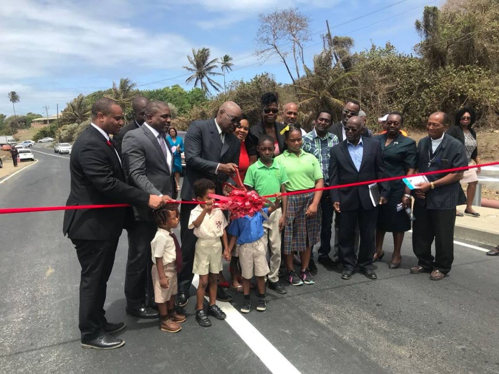 Chief Secretary Kelvin Charles, third from left, cuts the ribbon to formally declare open the Lambeau River Bridge on Monday. Others in photo include from left, Infrastructure Secretary Kwesi Des Vignes, Finance Secretary Joel Jack, MP for Tobago West, Shamfa Cudjoe, Sports Secretary Jomo Pitt, and Reverend Hilton Bonas, at right, along with a group of schoolchildren.