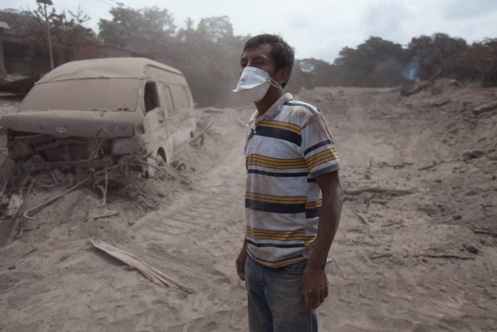 DESOLATE: A man waits for a rescue team in the 
ash-covered village of San Miguel Los Lotes.